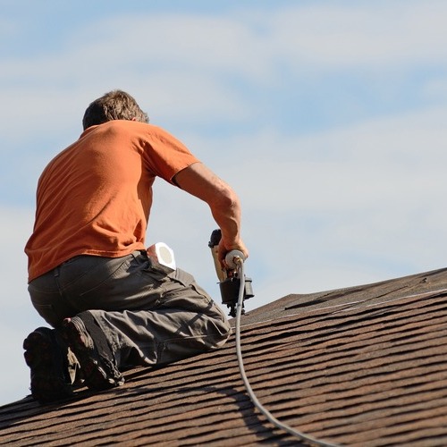 A roofer works on a roof.