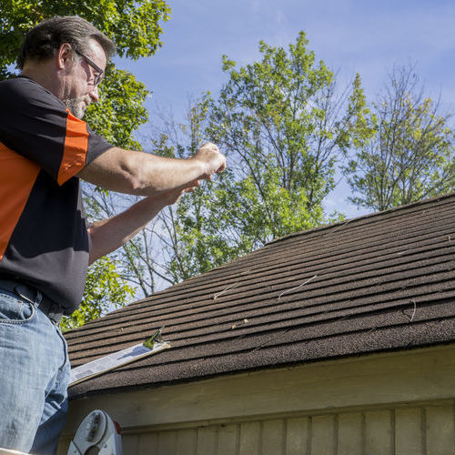 Contractor takes photos of roof damage.