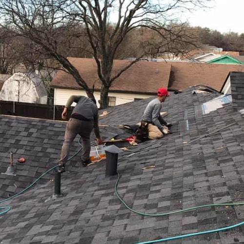 Roofers repair shingles.