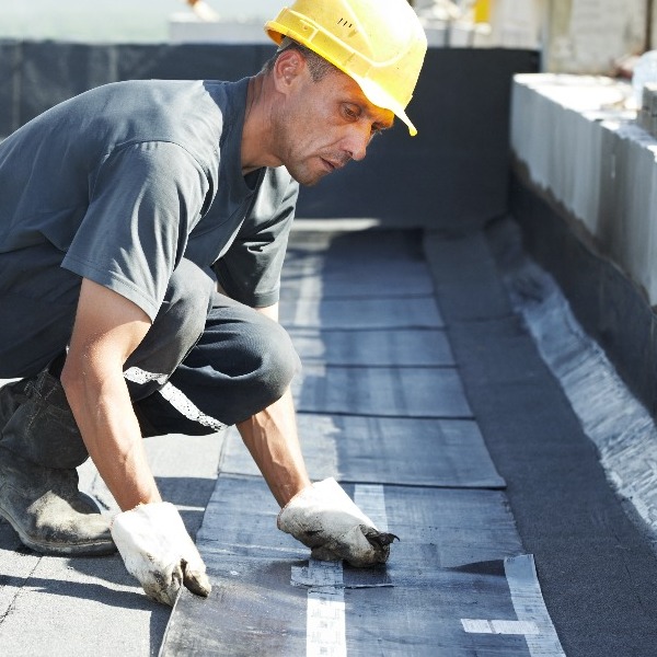Roofer applies modified bitumen.