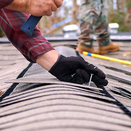 Roofer repairs shingles.