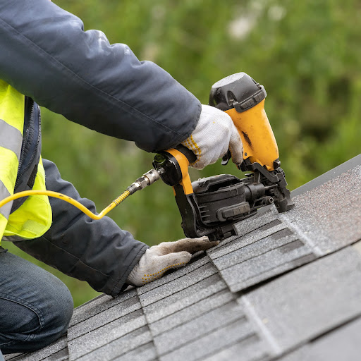 A roofer works on a roof.